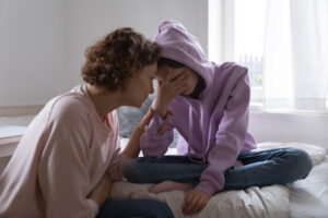 mom comforting teen girl