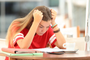 teen girl with head on hands stressed