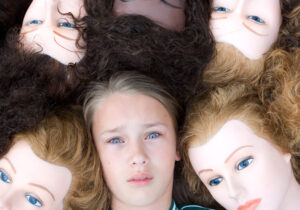 distressed teen lying among mannequins