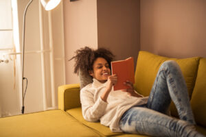 adolescent girl reads on couch