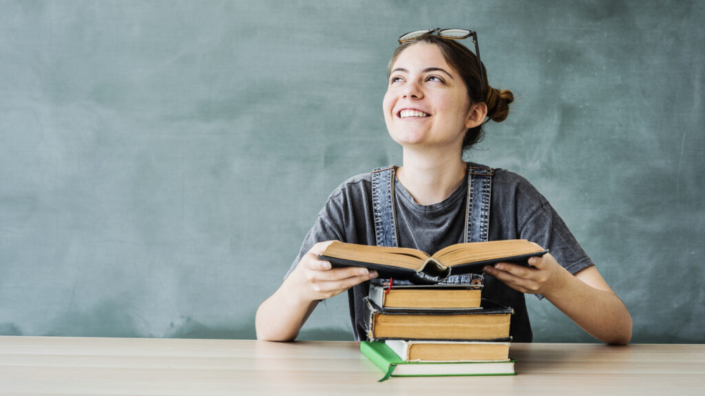 teen girl smiling and opening book