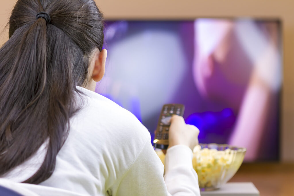 teen girl with remote watching tv