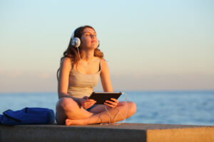 teen meditates by ocean