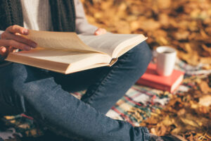 teen sitting outside reading a book